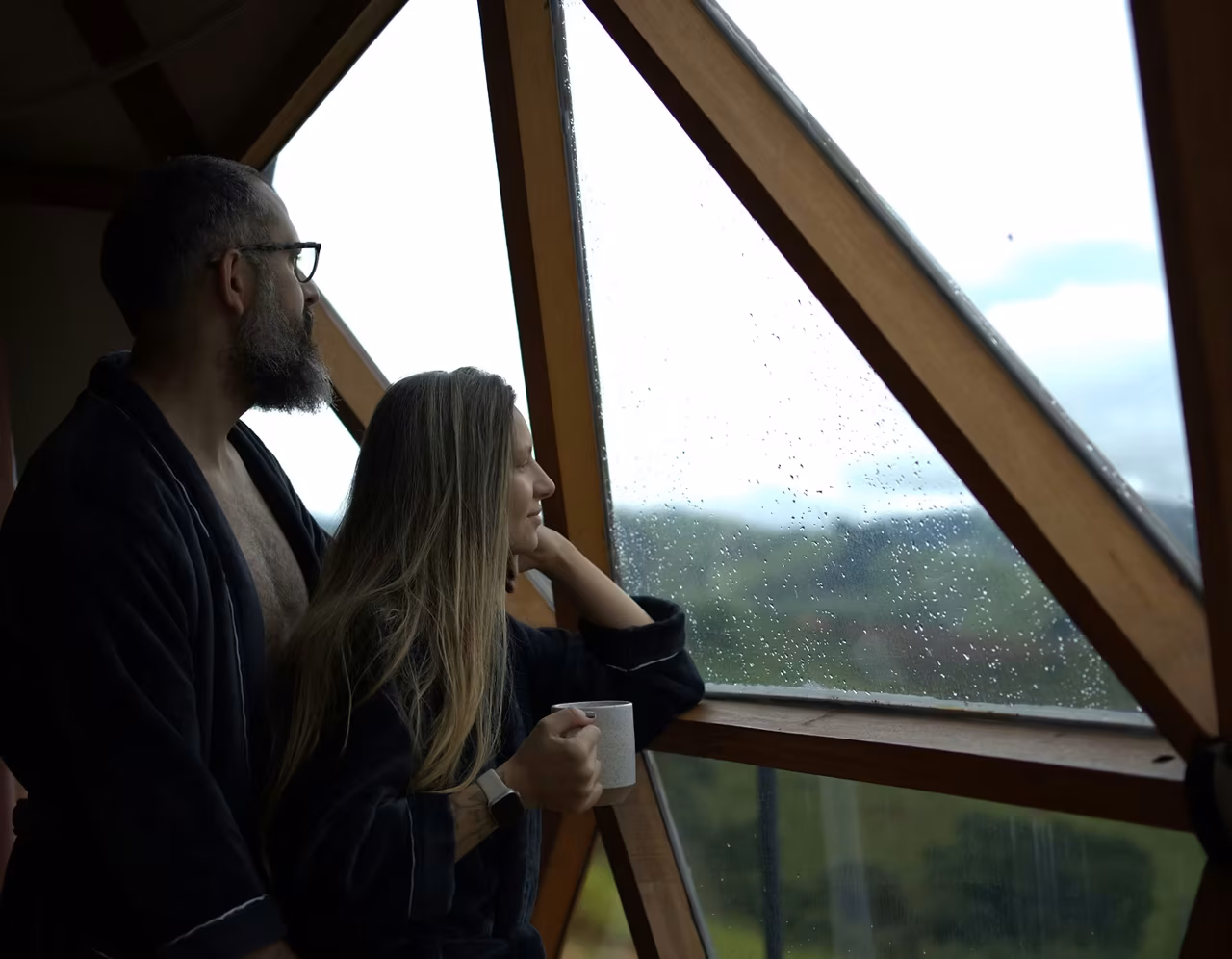 Casal contemplando a serra pela janela geodésica do Domo Kali